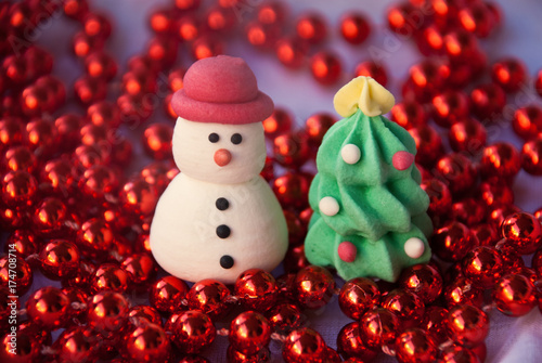 Figures of New year tree and Snowman with red garland. New year card. Merry christmas background. Xmas postcard.