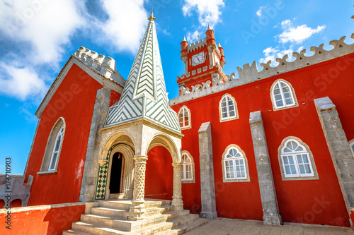 Red clock tower and rear facade of National Palace of Pena, Municipality of Sintra in Portugal.The Pena Castle is famous for its colors and different architectural styles. Sintra's main attraction