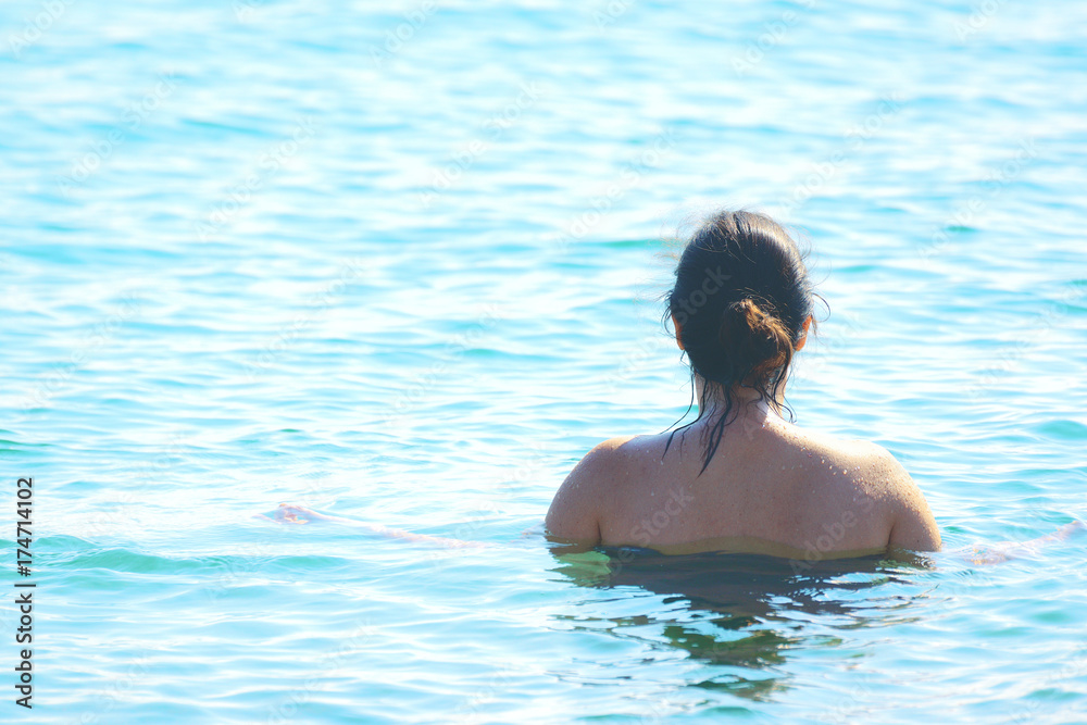 Natural woman taking a bath in the sea. Empty copy space for Editor's text.