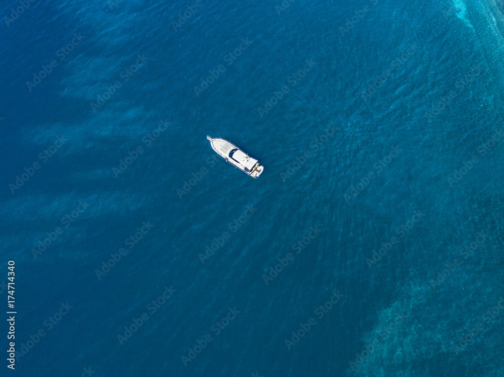 Vista aerea di una barca ormeggiata che galleggia su un mare trasparente. Immersioni relax e vacanze estive. Coste francesi, Corsica. Francia