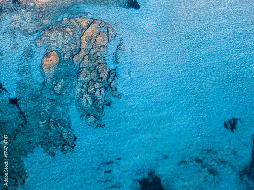 Vista aerea di scogli sul mare. Panoramica del fondo marino visto dall’alto, acqua trasparente. Fondo marino disegnato dalle alghe