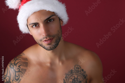 Sexy santa claus posing on a red background 