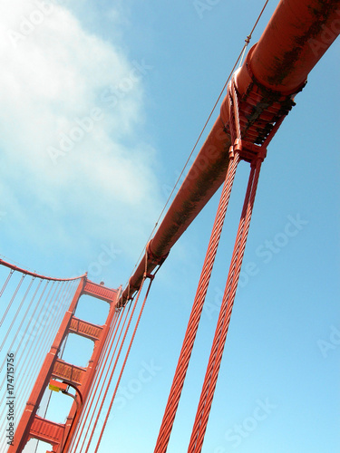 Red cables of the famous golden gate bridge in San Francisco with blue sky as background, USA.