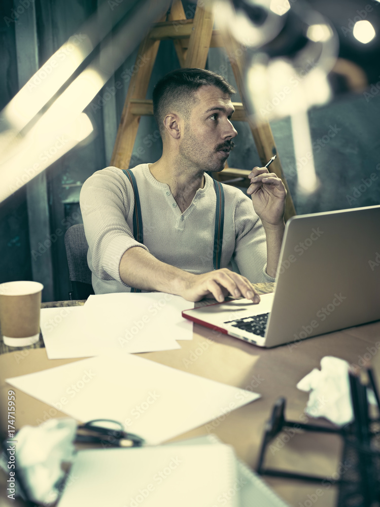 Portrait of a bearded businessman who is checking details of his upcoming meeting in his notebook and typing. Portrait of a bearded businessman who is checking details of his upcoming meeting in his notebook and typing.