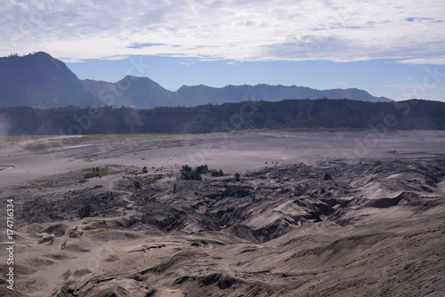 Panoramic view from the top of the stairs heading towards the dusty valley behind hindu temple at the foot of mount Batok at the Tengger Semeru National Park in East Java, Indonesia.
