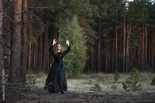 beautiful girl in a black dress in the forest.