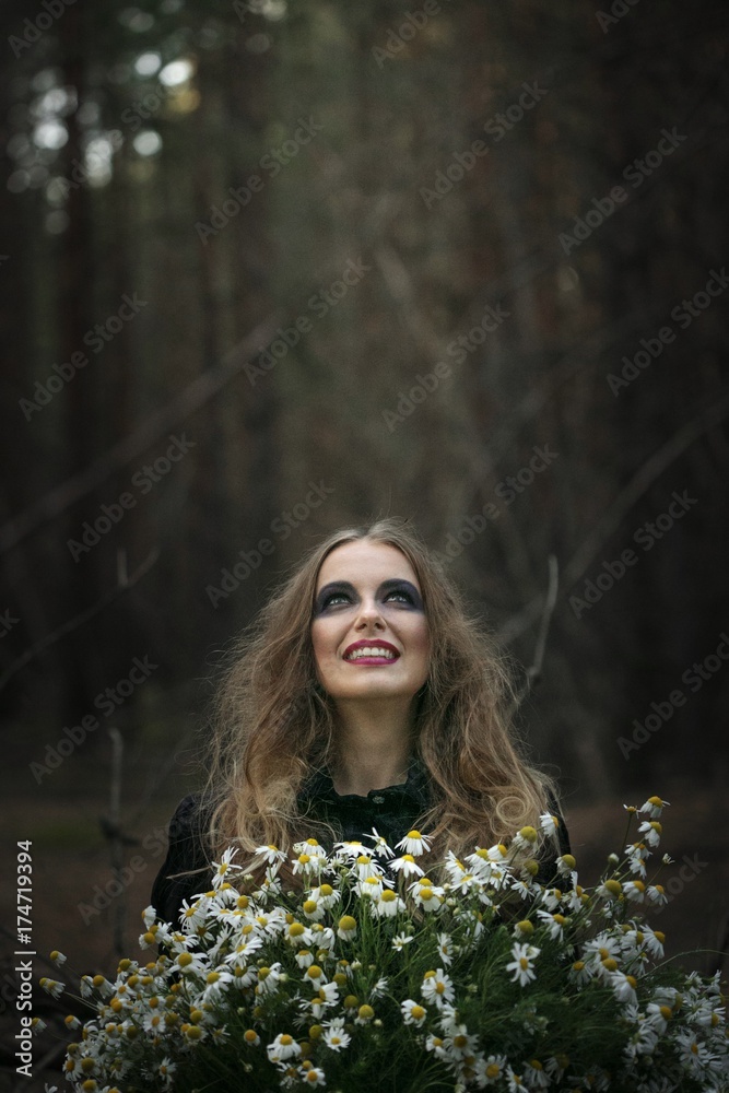 Halloween. field chamomile. beautiful girl in a black dress in the forest. Halloween. field chamomile. beautiful girl in a black dress in the forest.