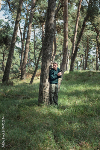 Man with pistol standing in pine forest. © ysbrandcosijn