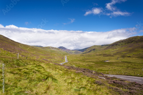 Narrow road along a valley in the Scottish Highlands in Scotland, United Kingdom; Concept for travel in Scotland