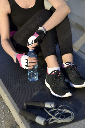 Young woman in sportswear holding a bottle of water