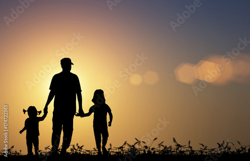 silhouette family walking on blurry colorful sunlight background.