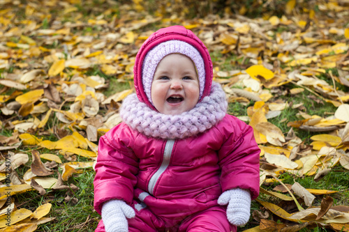 happy baby girl laughs outdoors
