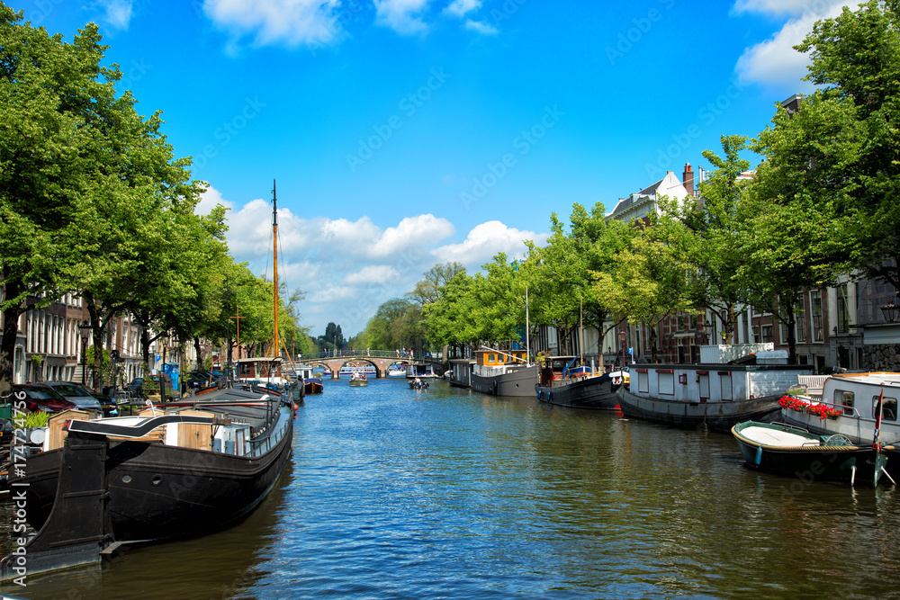 canals and embankments with boats of Amsterdam city.