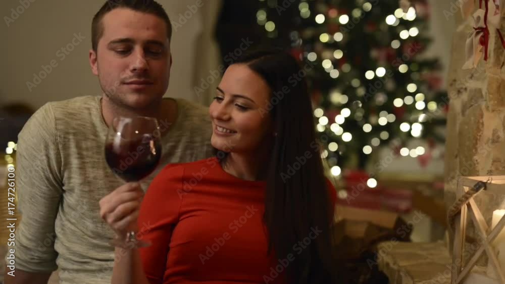 Couple sitting in front of fireplace, drinking wine. Couple sitting in front of fireplace, drinking wine.