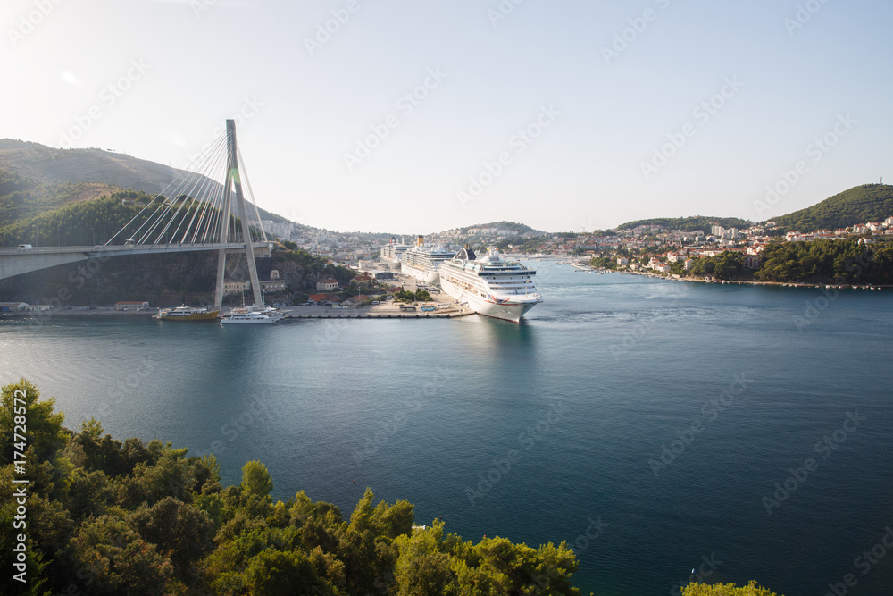 Frank Tudman's Bridge. Suspension bridge over the water in Dubrovnik and ships in the port.
