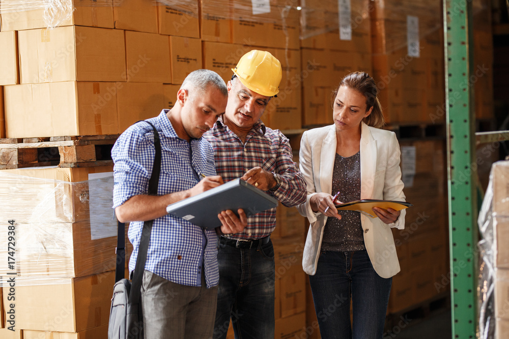 Team of customs managers and warehouse worker checking list and inventory on the shelf in storehouse. Team of customs managers and warehouse worker checking list and inventory on the shelf in storehouse.