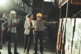 Team of customs managers and warehouse worker checking list and inventory on the shelf in storehouse.