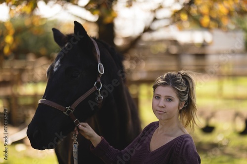 Portrait of woman with horse standing at barn photo