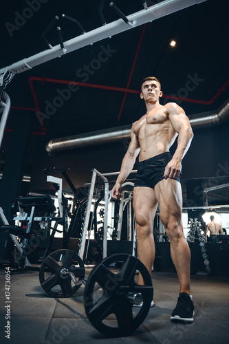 Handsome model young man training legs in gym © antondotsenko