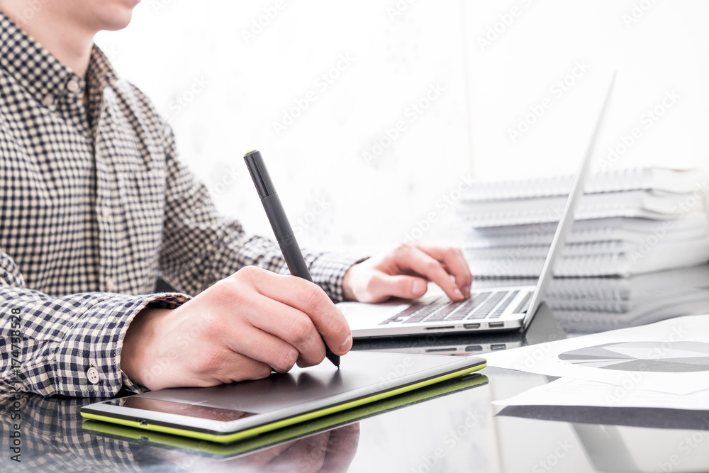 Fototapeta premium Designer working with graphics tablet and laptop in office