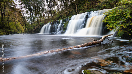 Long exposure of a waterfall  Sgwd Y Pannwr  in a tree covered forest in the autumn