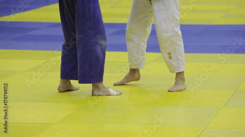 The legs of two judo fighters during a fight and throw