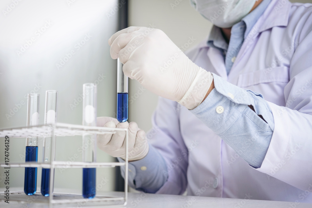 Scientist or medical in lab coat holding test tube with reagent, Laboratory glassware containing chemical liquid, Biochemistry laboratory research Scientist or medical in lab coat holding test tube with reagent, Laboratory glassware containing chemical liquid, Biochemistry laboratory research