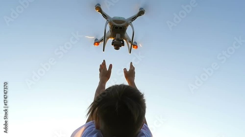 drone flies from the hands of the boy at sunset photo