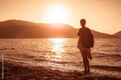 Young woman on the sea at sunset.