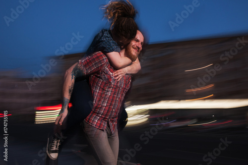 Happy flight. Strong love connection. Flying smiley female, couple in motion, blurred urban background, cheerful man giving girl piggyback ride, fun concept