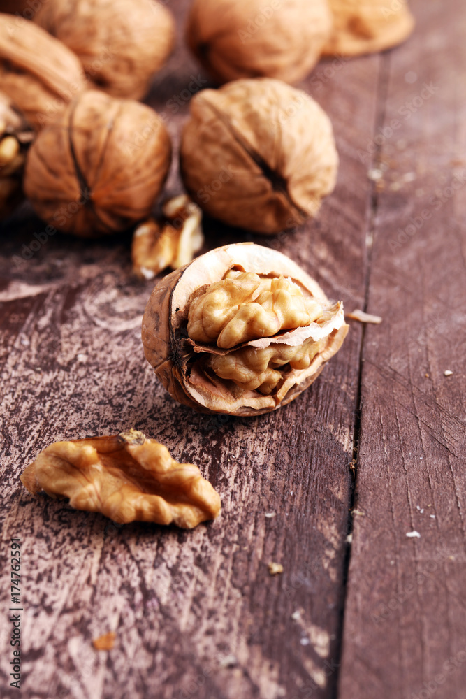 Walnut kernels and whole walnuts on rustic old wooden table. Walnut kernels and whole walnuts on rustic old wooden table.