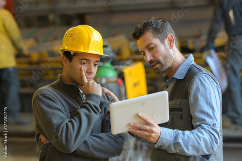 foreman explaining to employee with tablet