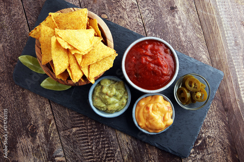 Nachos Tortilla Chips and jalapeÒos Chili Peppers or Mexican chili peppers with Tomato, Cheese and Guacamole dip