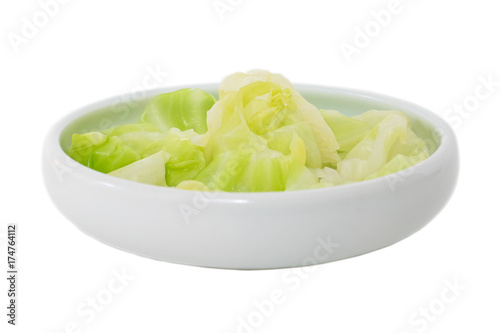 Tableau sur toile Cooked cabbage in a round shallow vegetable bowl with white background