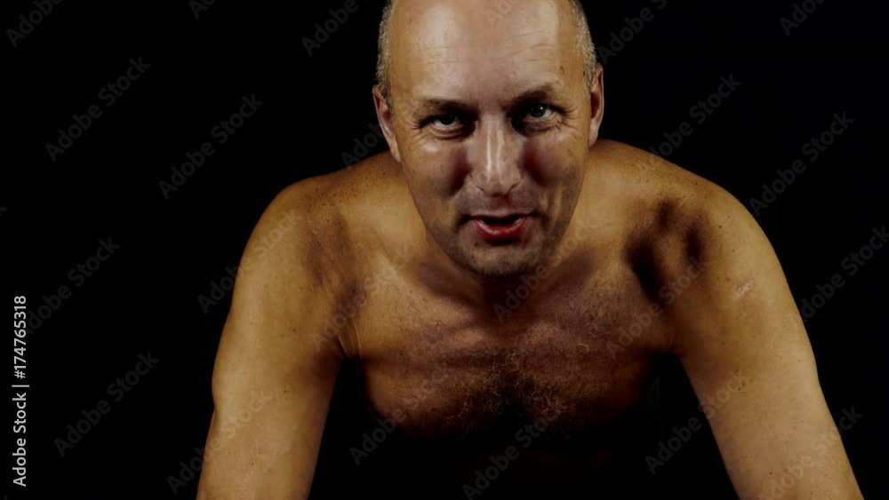 Adult caucasian male athlete doing push ups at home. Close up low key. Dark background. Adult caucasian male athlete doing push ups at home. Close up low key. Dark background.