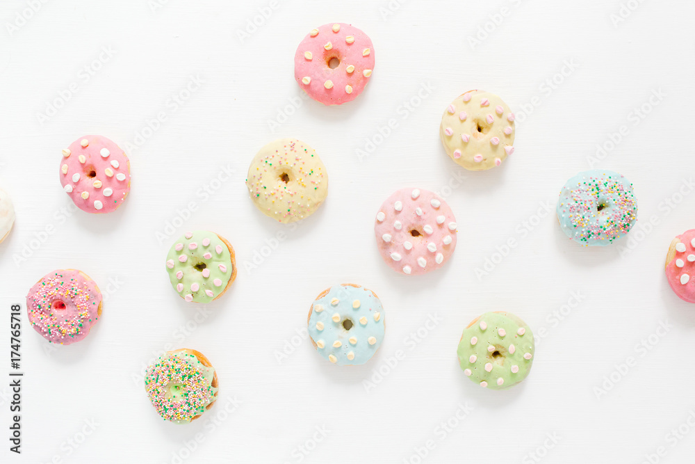 Colorful donuts on white background. Flat lay, top view minimal pattern. Colorful donuts on white background. Flat lay, top view minimal pattern.