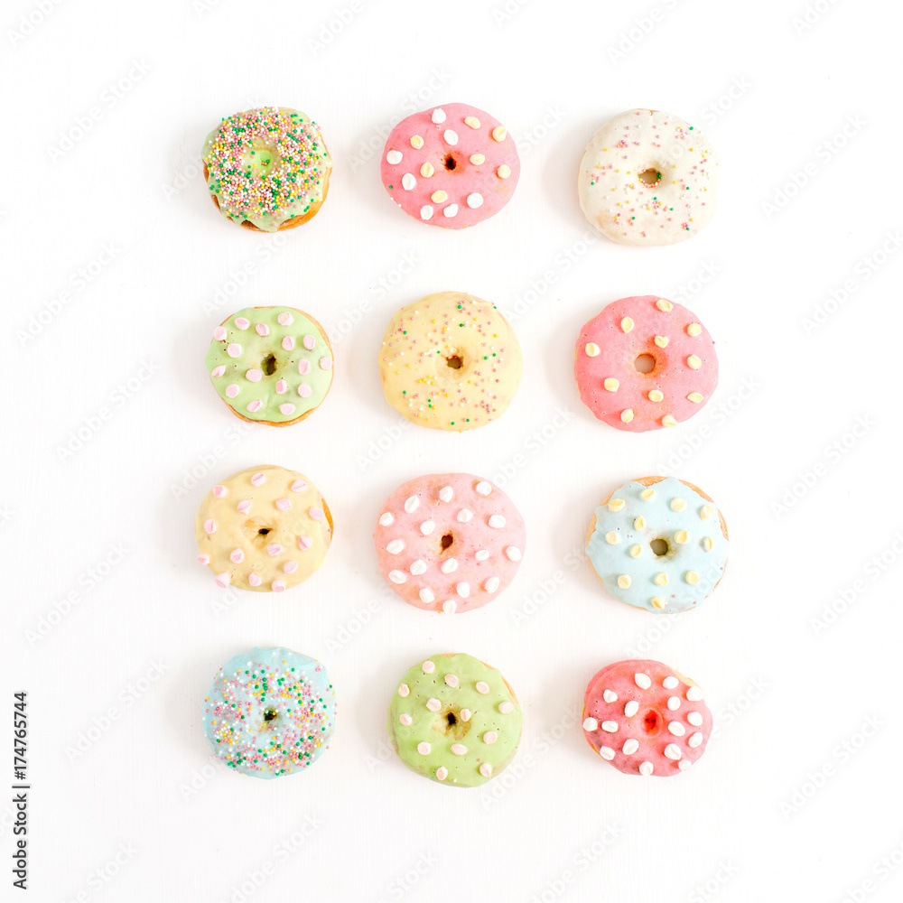Colorful donuts on white background. Flat lay, top view minimal pattern. Colorful donuts on white background. Flat lay, top view minimal pattern.