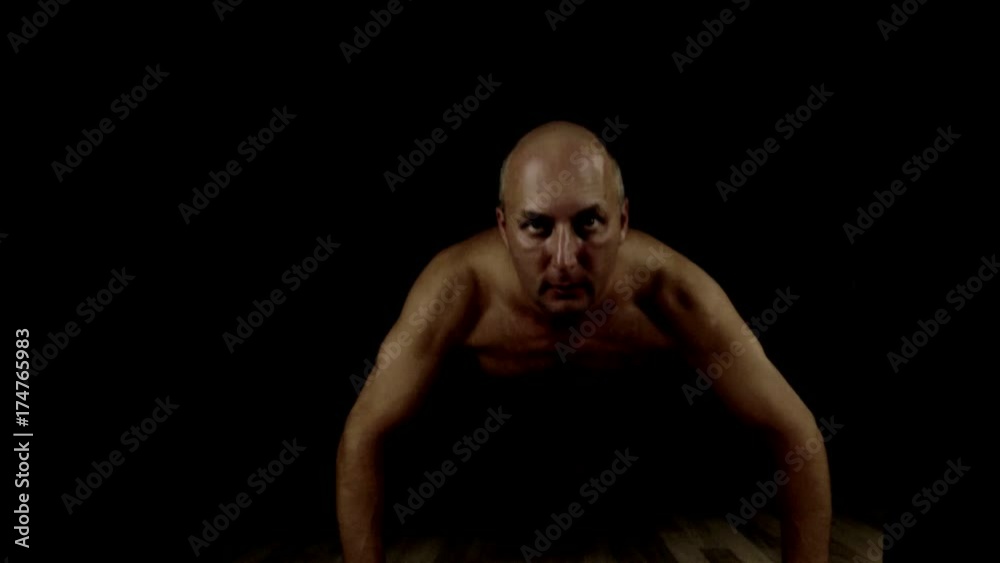 White man pushing up indoors. Low key brutal look of training. Bodybuilders exercise. White man pushing up indoors. Low key brutal look of training. Bodybuilders exercise.