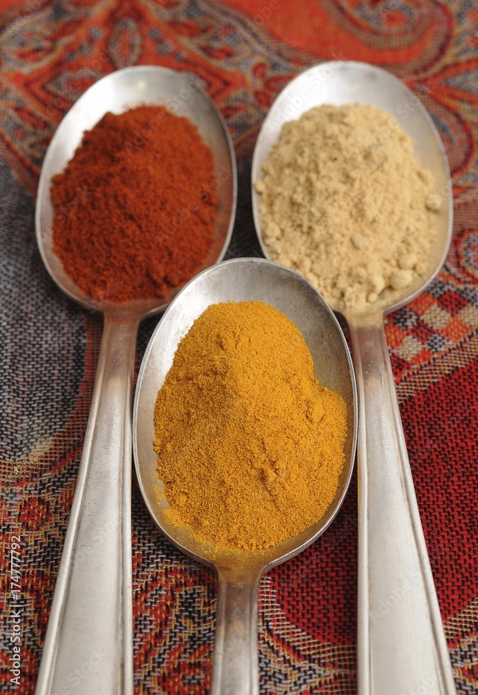 Spices on old spooks, curry, paprika and ginger powder