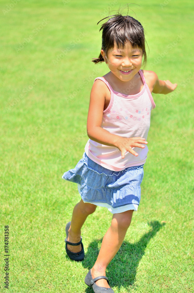 芝生で元気に走る女の子 芝生で元気に走る女の子