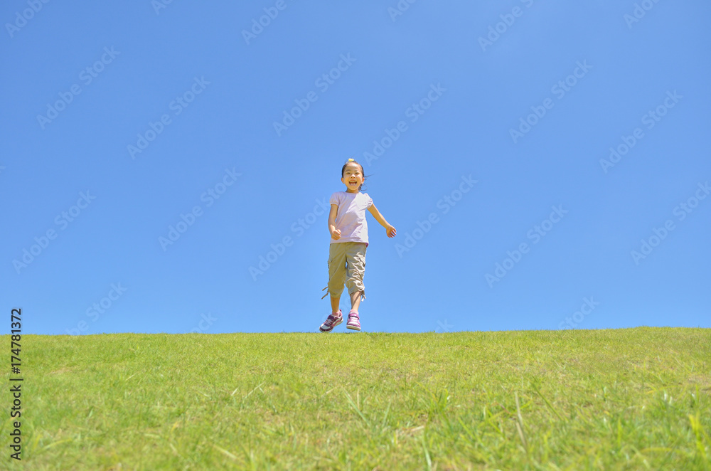 芝生を走る女の子（青空）