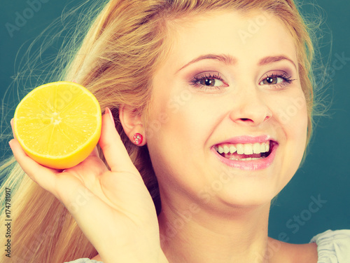 Woman holding fruit lemon half