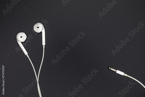 Top view of White Earphones on Black background. Copy space. Music is my life concept