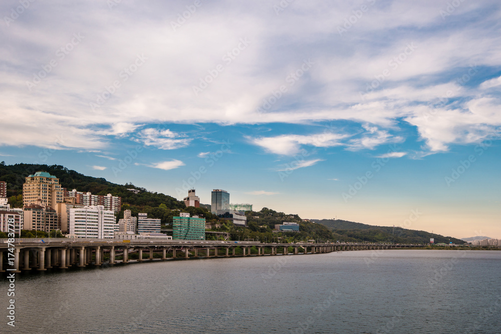 Fototapeta premium Clouds flow through the Hangang road and apartment buildings where the intersection of Seoul and South Korea is visible.