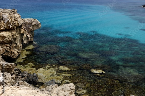 Fototapeta Naklejka Na Ścianę i Meble -  Crystal clear water and a rocky seashore of the Mediterranean Sea, Cape Gkreko, Cyprus, Europe