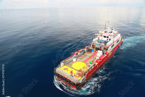 Supply boat transfer cargo to oil and gas industry and moving cargo from the boat to the platform, boat waiting transfer cargo and passenger between oil and gas platform for hard work in offshore.
