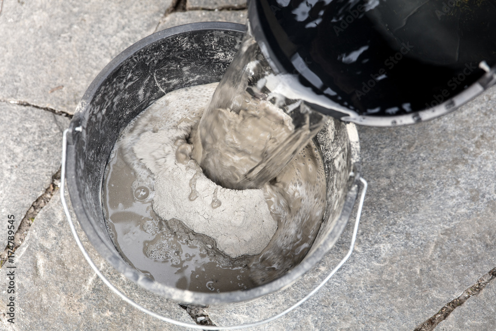 Wasser wird in Eimer mit Zement gegossen Stock Photo | Adobe Stock