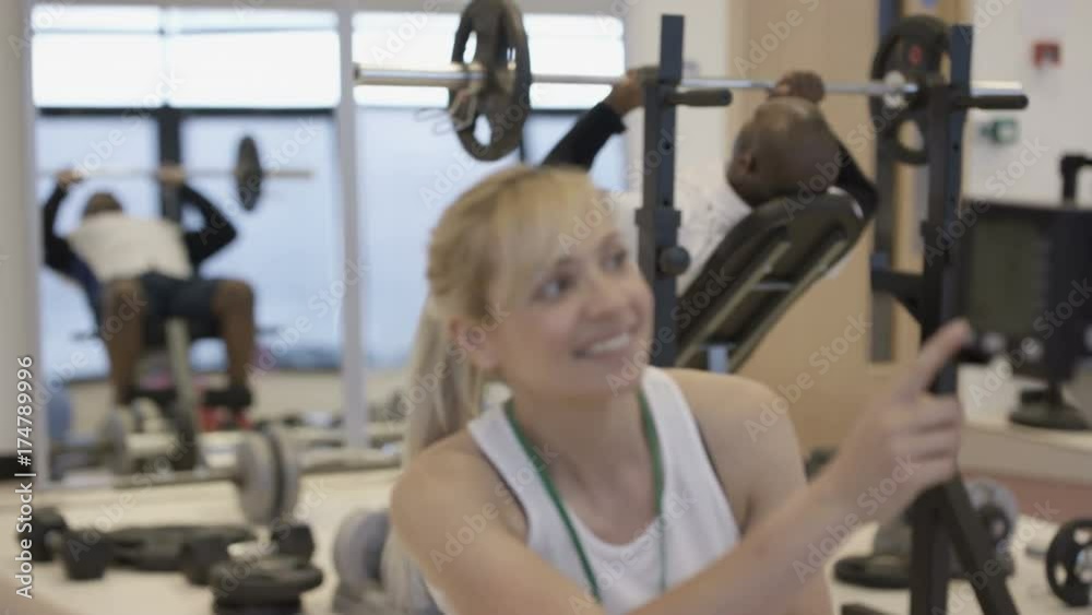 Portrait smiling personal trainer supervising a client in modern gym Portrait smiling personal trainer supervising a client in modern gym