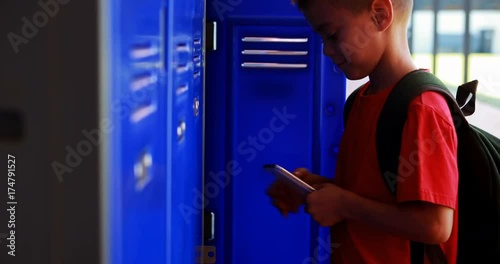 Wallpaper Mural Schoolboy using mobile phone in locker room  Torontodigital.ca