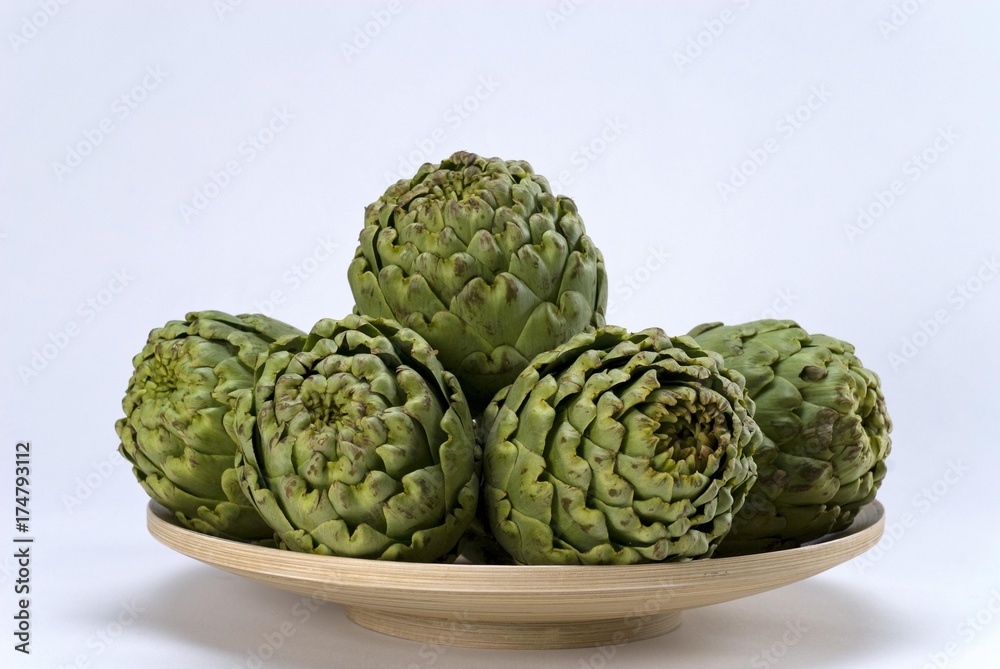 Fototapeta premium Artichokes (Cynara cardunculus) on a wooden bowl